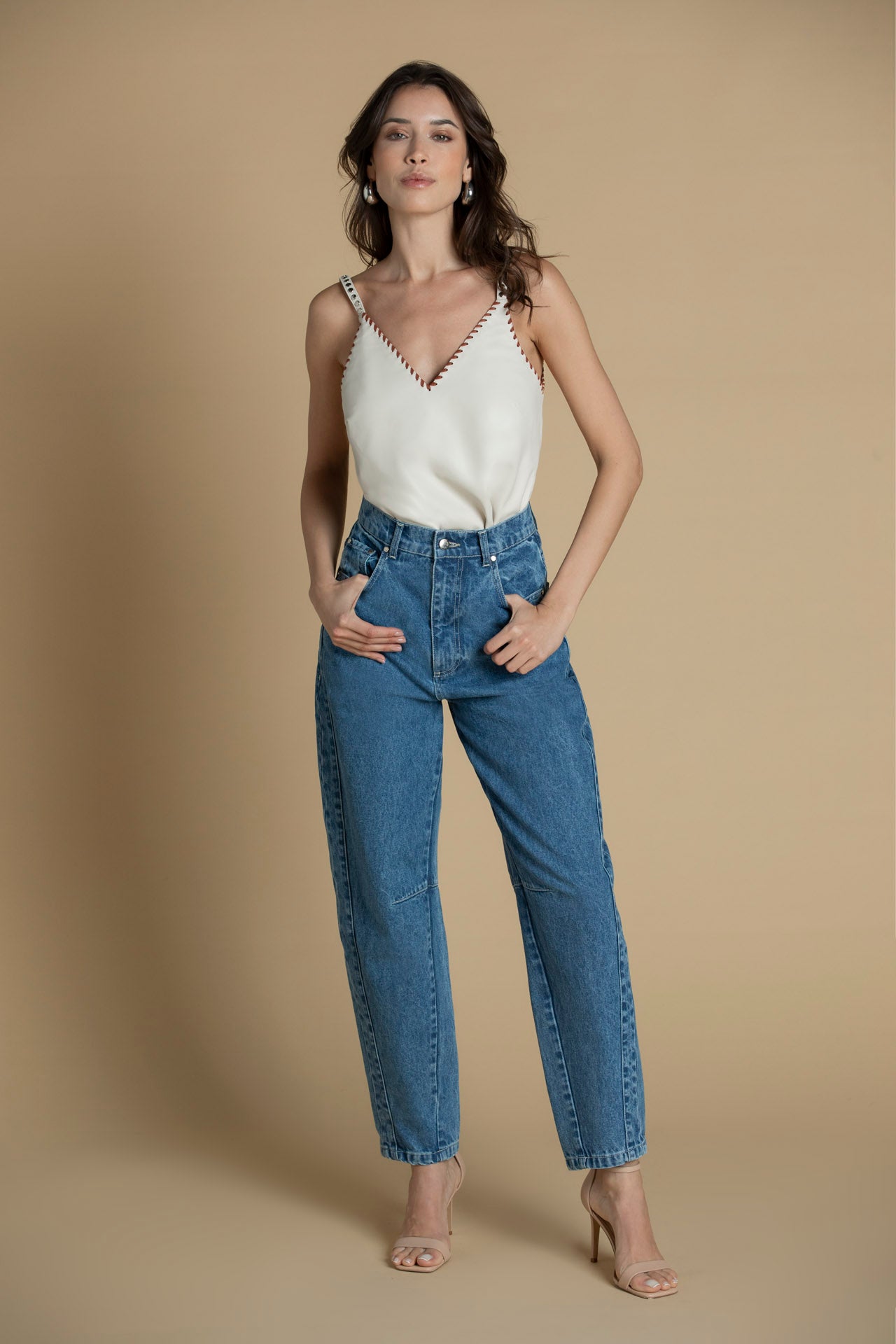 Top de couro SH x GM com alças finas e tachas metálicas, vista frontal com entrançado castanho.