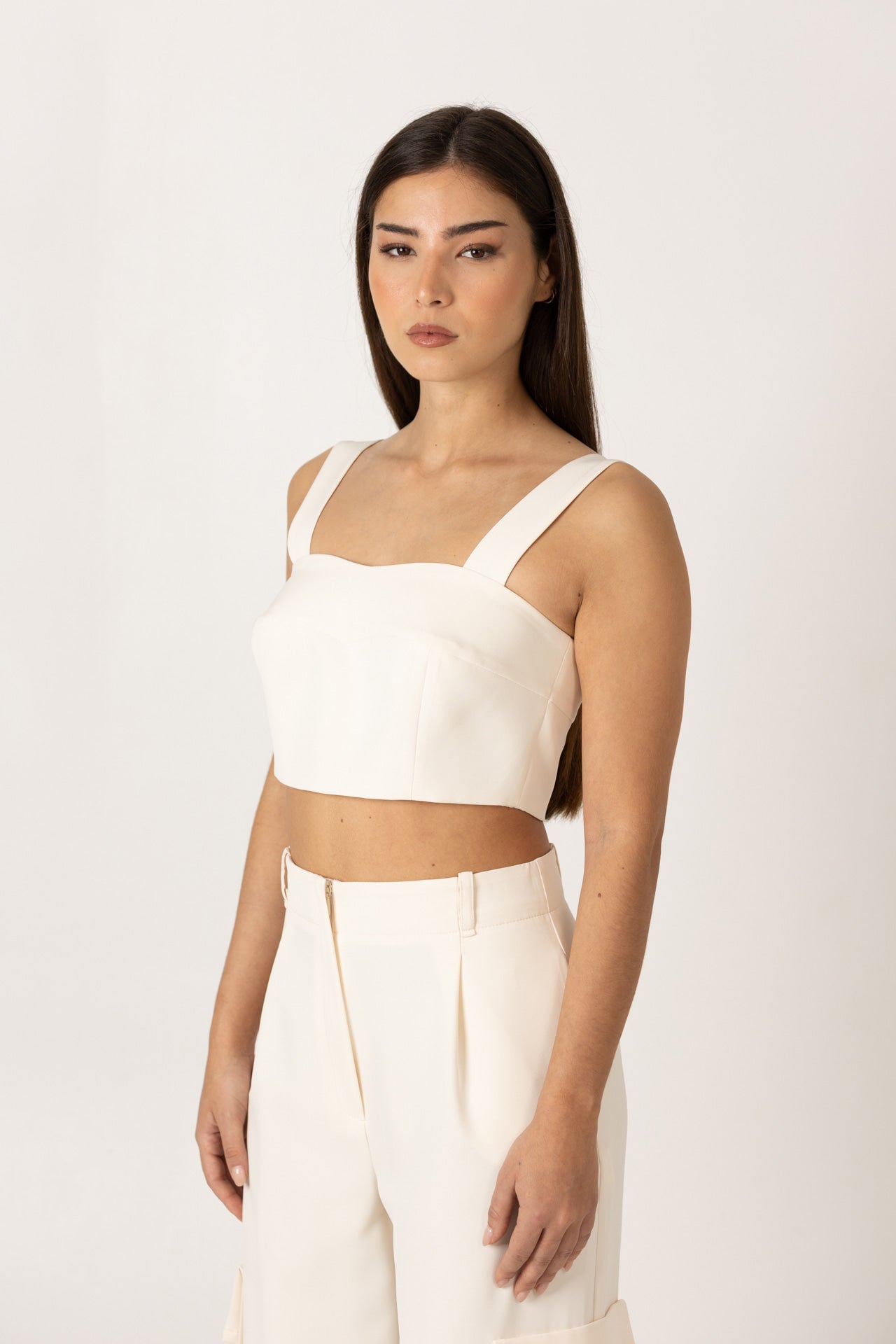 vista lateral do crop top sh x gm, evidenciando o corte encurtado e o ajuste elegante ao corpo.