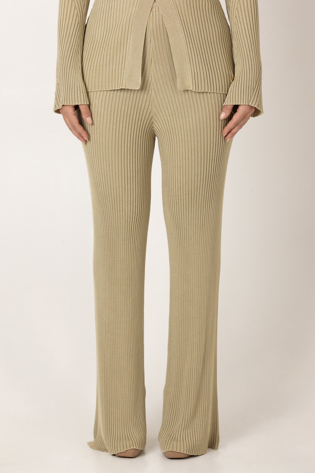 Detalhe do tecido canelado das calças SH x GM bege.