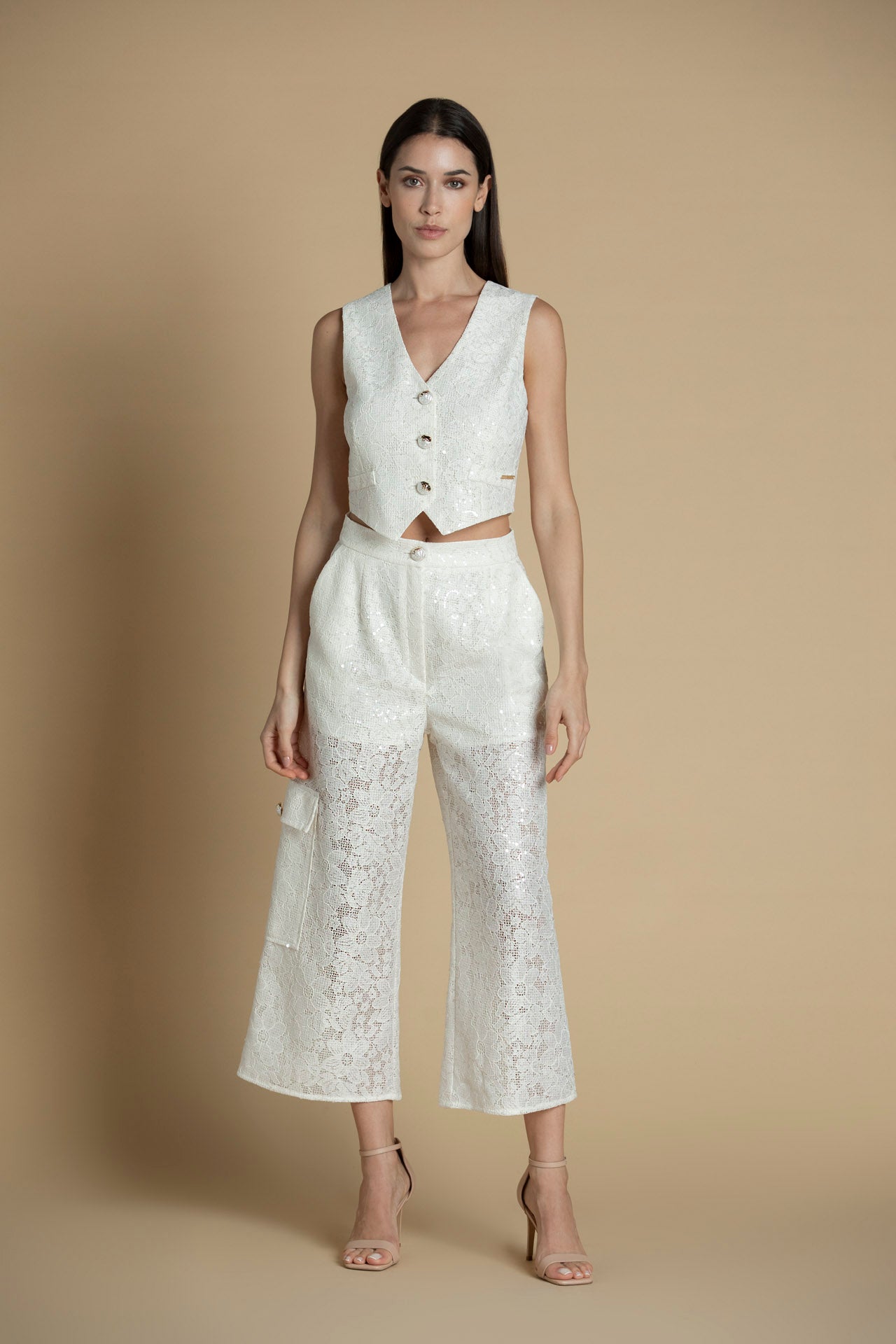 Vista frontal do colete com botões dourados e corte estruturado.