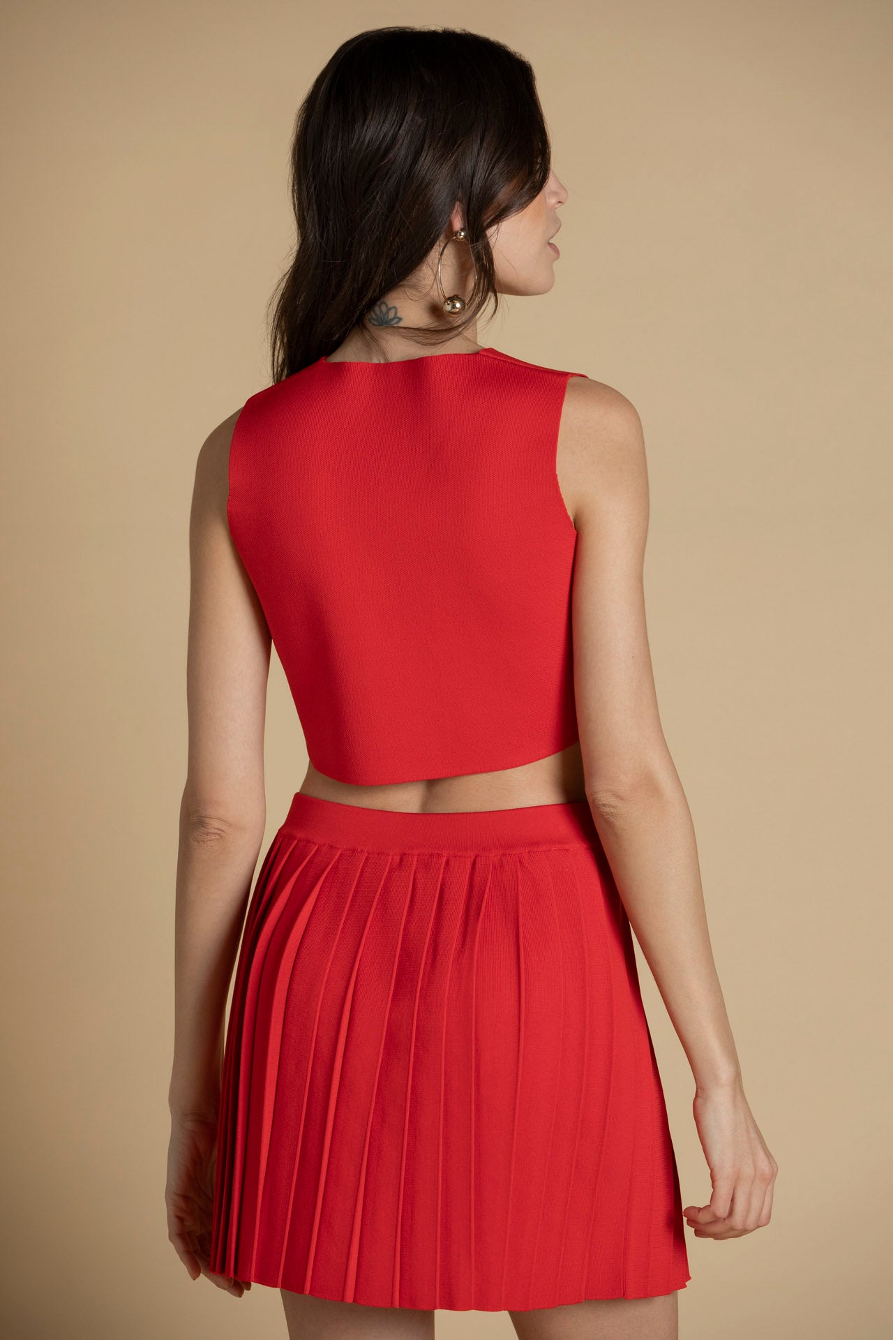 Parte de trás do top de malha vermelho, corte direito e toque moderno.
