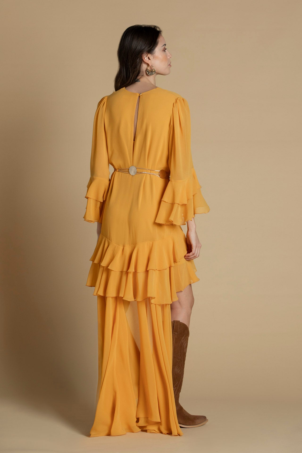 costas do vestido amarelo com mangas fluídas e detalhe assimétrico