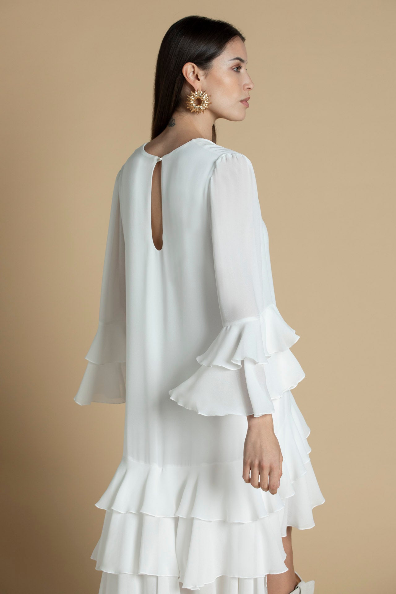 vista das costas do vestido branco com decote em bico e folhos