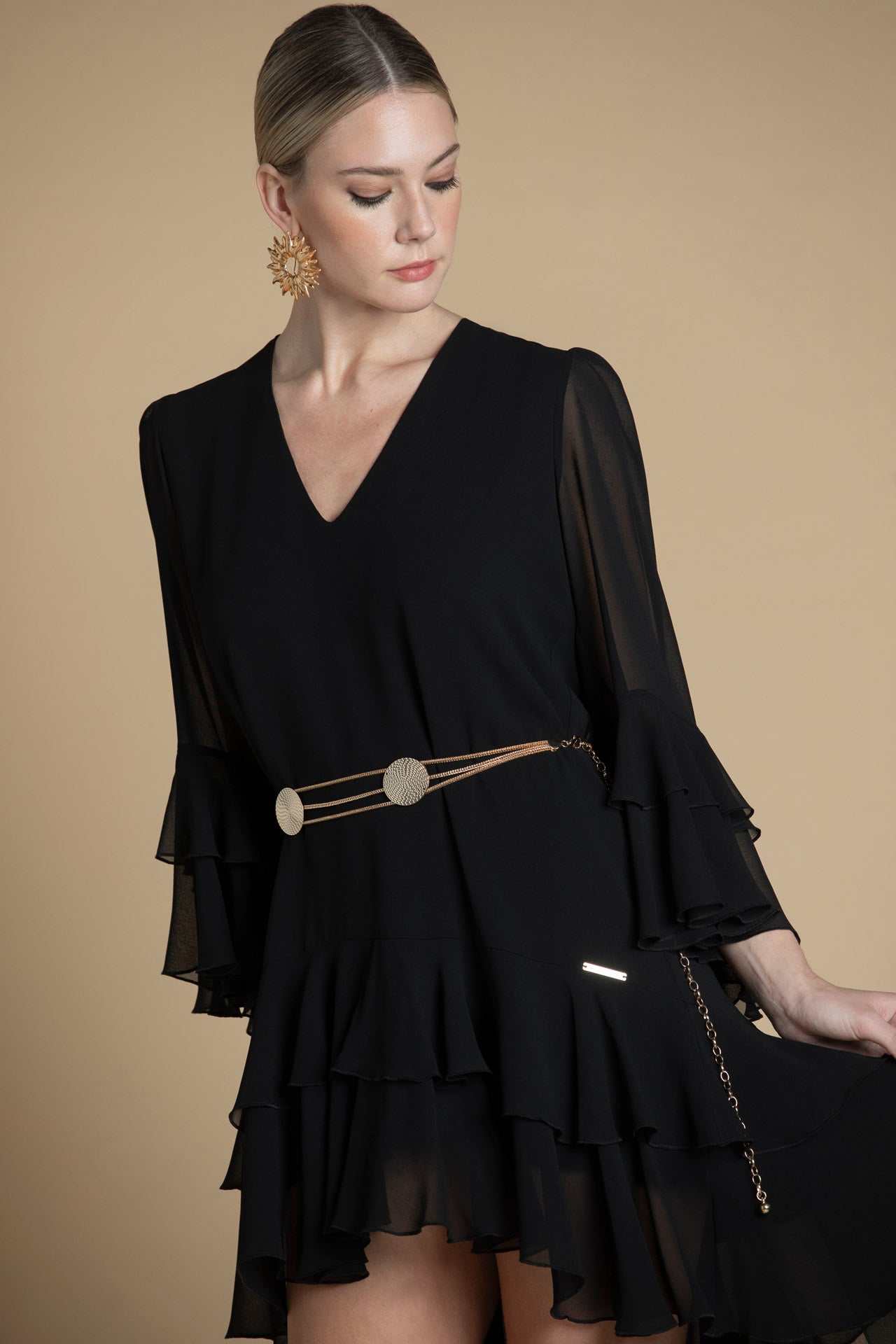 detalhe do tecido preto e folhos na manga e bainha