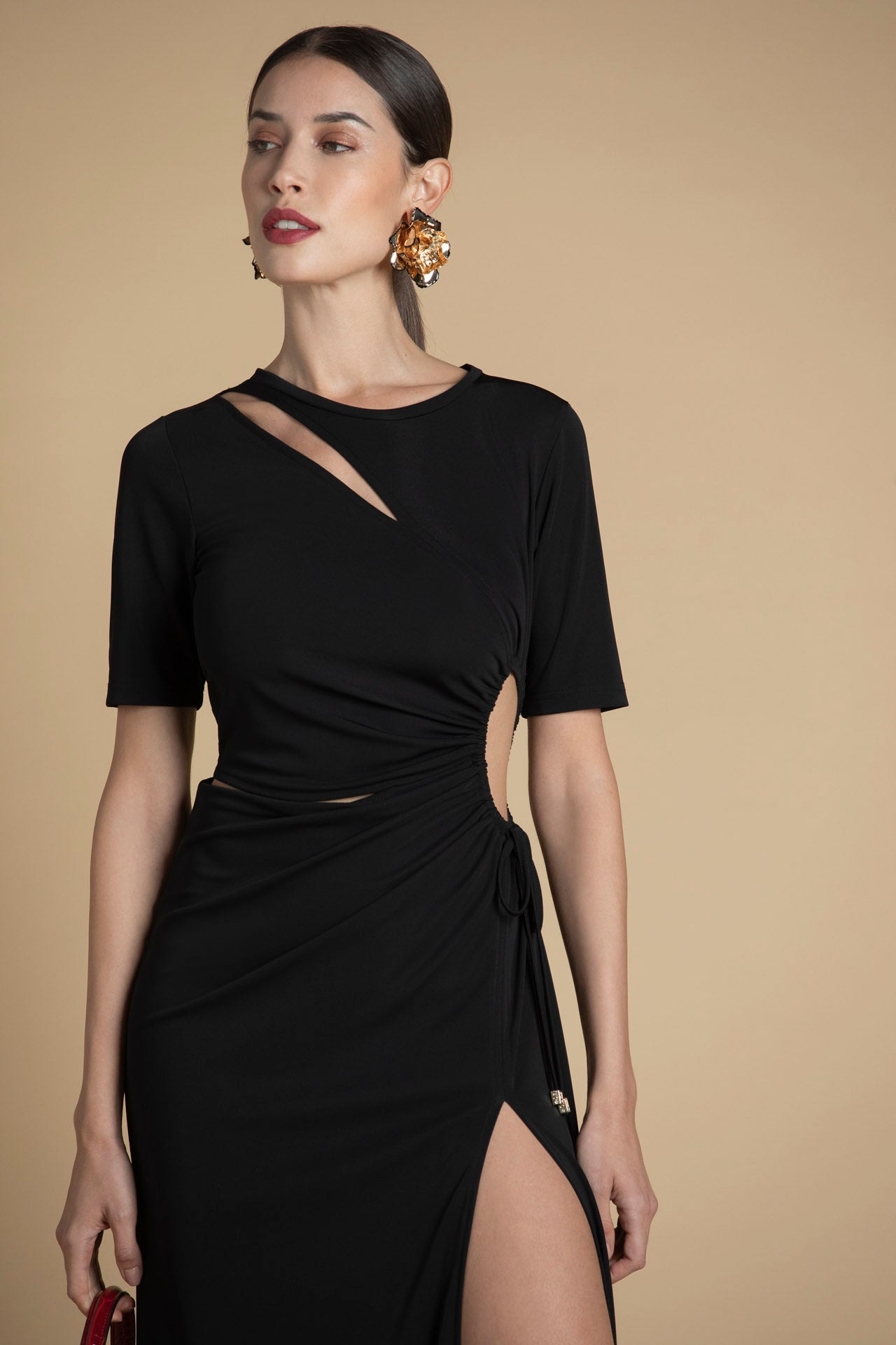 detalhe do recorte na cintura do vestido preto, com acabamento contemporâneo