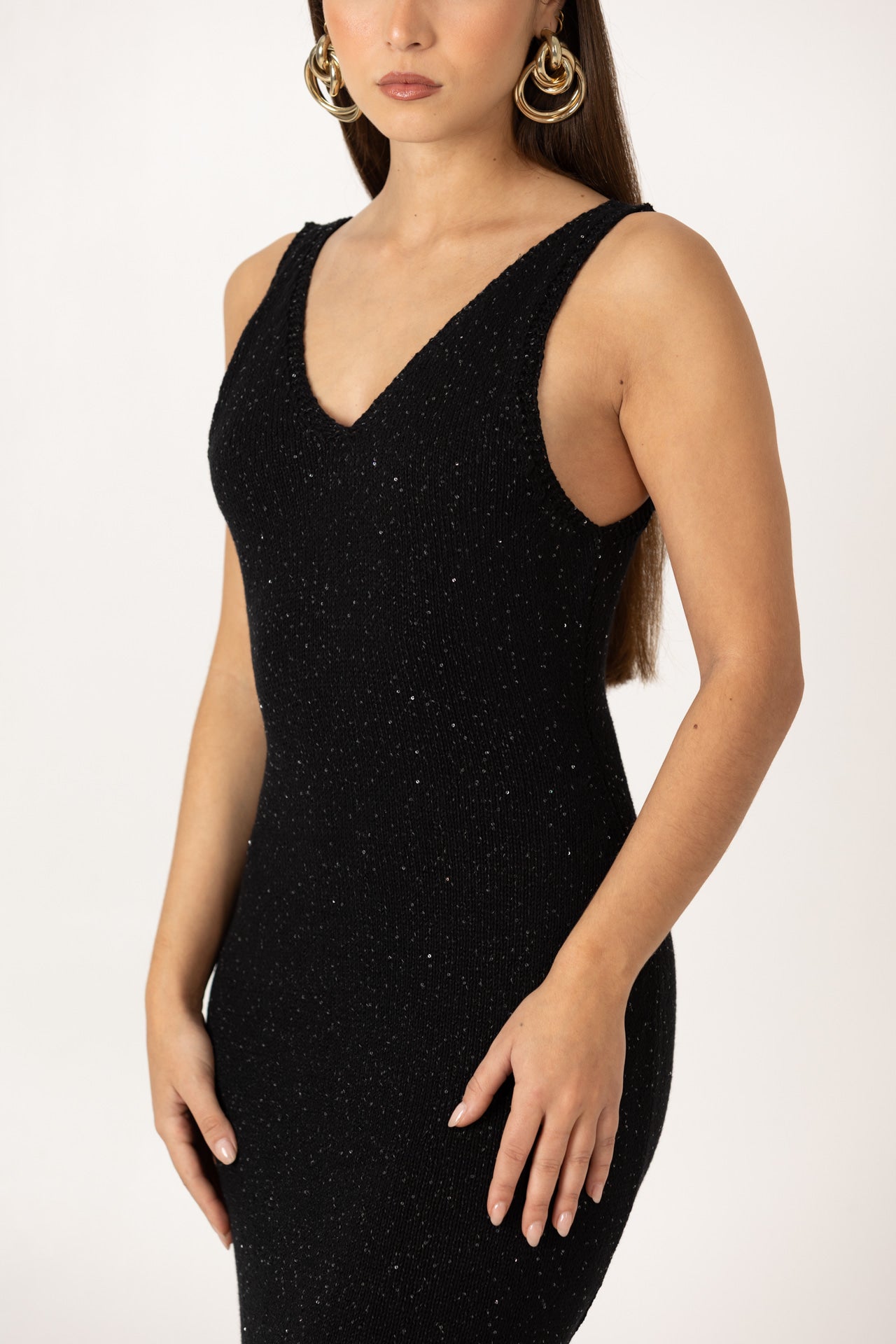 Vestido em malha preta com comprimento midi, vista lateral.

