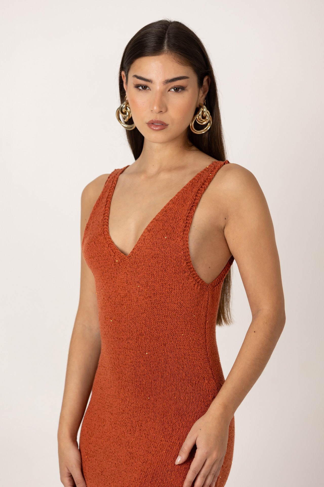 Vestido em malha ajustada rusty com corte midi, vista lateral.
